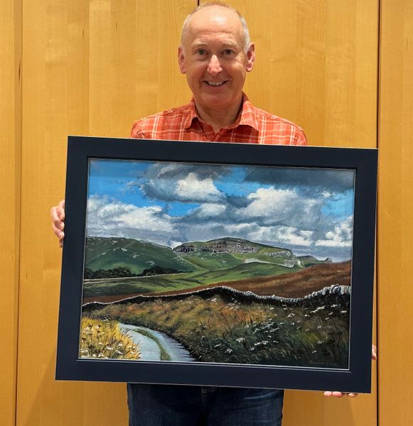 Artist Jonathan Little holding an original oil on linen landscape painting of Warrendale Knotts from Langber Lane now ready for the exhibition at The Folly Settle North Yorkshire