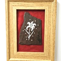 Slate painting of a lily in white mounted on red fabric, framed in oak