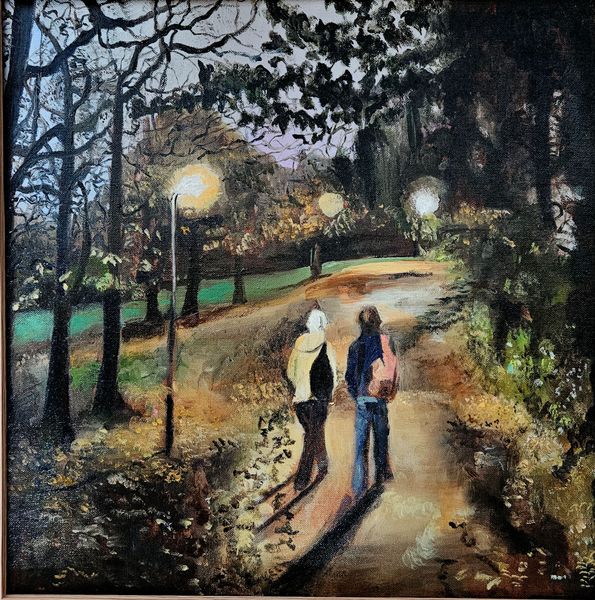 Two figures on a path through the park at dusk. Lamps light their route.