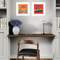 four framed canvases above a desk