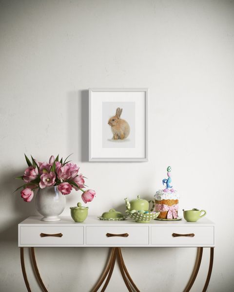 Coloured pencil drawing by Katrina Thompson of little easter bunny above a table set with flowers and easter decorations 