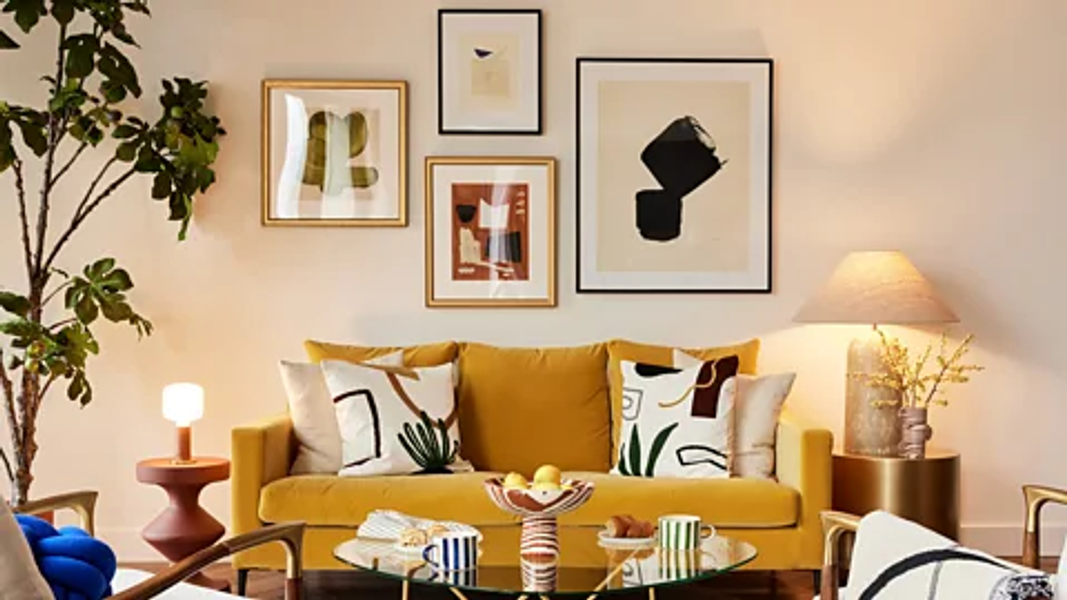 A living room with sofa and 4 framed artworks on the wall